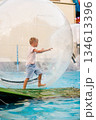 Child Enjoying Water Walking in Inflatable Zorb Ball at Amusement Park 134613396