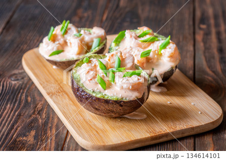 Avocado halves filled with guacamole and shrimp topped with spicy sriracha mayo 134614101