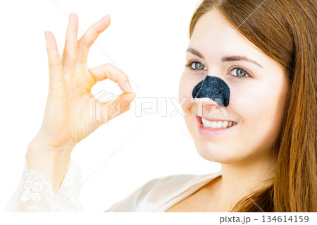 Woman applying pore strips on nose 134614159