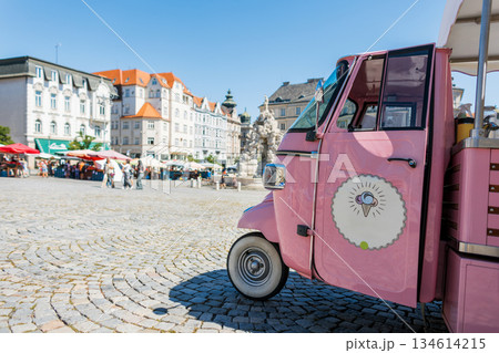 Old vintage European city and pink retro ice cream car. Summer sunny day and travel in Czech Republic, Brno. Pink ice cream truck parked on a sunny square in Brno. Colorful street market and historic 134614215