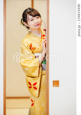 和室の襖を開ける着物の若い女性 134614490