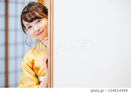 和室の襖を開ける着物の若い女性 134614494