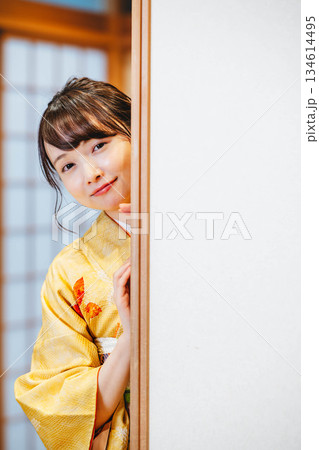 和室の襖を開ける着物の若い女性 134614495