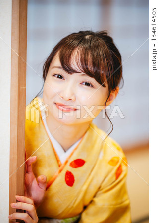 和室の襖を開ける着物の若い女性 134614505