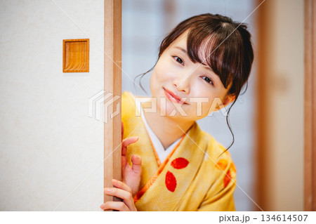 和室の襖を開ける着物の若い女性 134614507