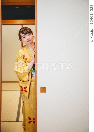 和室の襖を開ける着物の若い女性 134614522