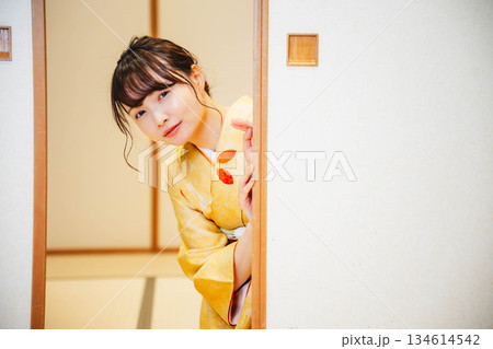 和室の襖を開ける着物の若い女性 134614542