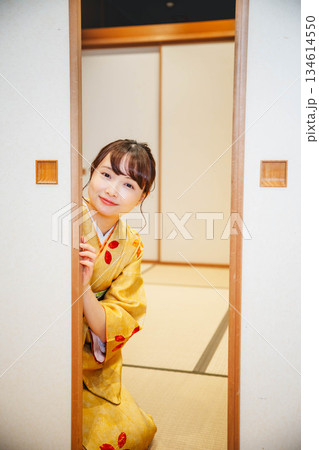 和室の襖を開ける着物の若い女性 134614550