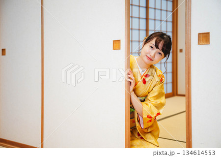 和室の襖を開ける着物の若い女性 134614553