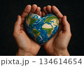 Hands cradling a heart-shaped Earth symbolize love for our planet and commitment to environmental preservation 134614654