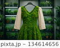 Vibrant green dress made of moss displayed in a lush plant shop, showcasing nature-inspired fashion amidst greenery 134614656