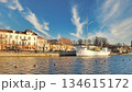 Porvoo, Finland - December 08, 2020: Historic ship is docked by the waterfront, surrounded by buildings and trees, under a clear blue sky with wispy clouds 134615172
