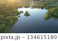Aerial perspective showcasing a tranquil lake with small islands, bordered by vibrant green trees and a winding river, capturing the beauty of nature and peaceful outdoor scenery. Ao, Estonia. 134615180