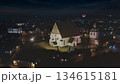 Porvoo, Finland - December 08, 2020: Aerial view of a historic church illuminated at night, surrounded by a quaint village and twinkling lights creating a serene atmosphere 134615181
