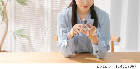 スマホを操作する女性の手元（ボディパーツ） 134615967