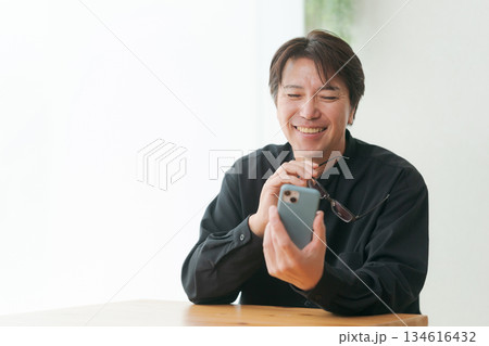 スマホを操作する中年男性 134616432