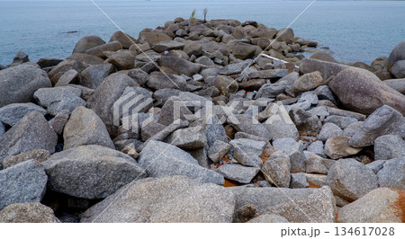 Rocky Breakwater Extending into Calm Tropical Sea 134617028