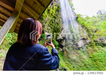 女性が滝を撮影 134617092