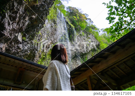 女性が滝を仰ぎ見る 134617105