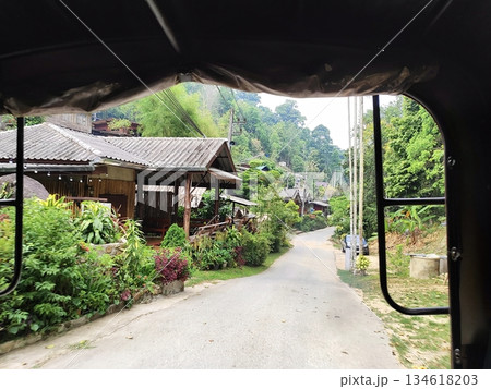 Scenic view of a peaceful mountain village from a vehicle window 134618203