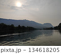 Peaceful river landscape with mountain range silhouette under the hazy sun 134618205