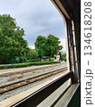 Scenic railway track view from a train window with lush green trees 134618208