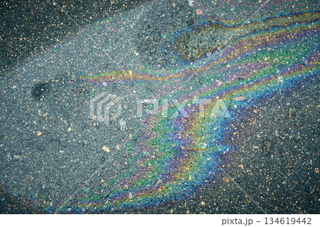 Oil slick creating an abstract texture with rainbow colors on wet asphalt surface Oil slick creating an abstract texture with rainbow colors on wet asphalt surface 134619442