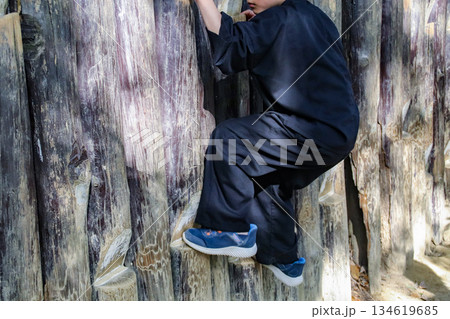 壁づたいの術で遊ぶ子供（8歳児／男の子） 134619685