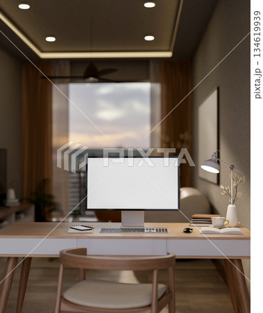 White screen computer on wooden table with books under lamp light in a dim lit bedroom or study room White screen computer on wooden table with books under lamp light in a dim lit bedroom or study room 134619939