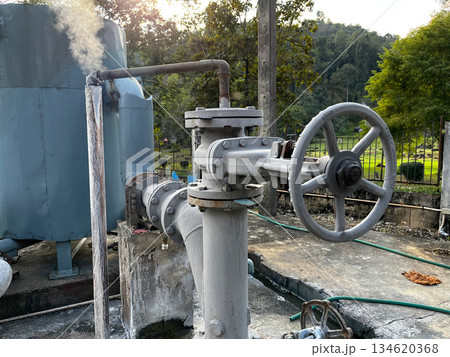 Geothermal power plant equipment with control valve and steam pipeline, representing renewable energy, sustainable electricity generation, clean technology, and eco friendly industrial infrastructure Geothermal power plant equipment with control valve and steam pipeline, representing renewable energy, sustainable electricity generation, clean technology, and eco friendly industrial infrastructure 134620368