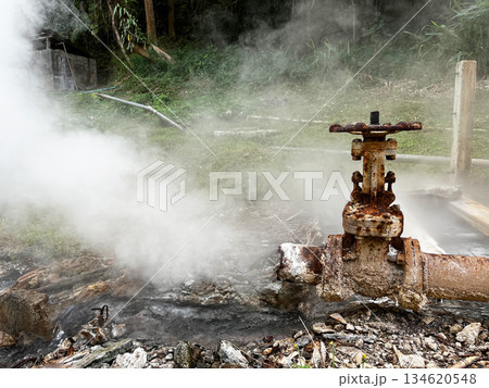 Rusty geothermal pipe releasing hot steam at a natural hot spring, representing geothermal energy, underground heat, pressure system, renewable power generation from Earth natural resources, Broken 134620548