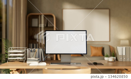 White screen computer with books and stationary on wooden table in a cosy living room or study room. White screen computer with books and stationary on wooden table in a cosy living room or study room. 134620850
