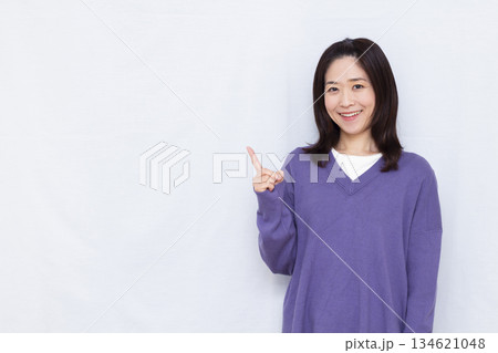 笑顔で人差し指を立てる女性 134621048