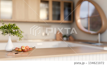 A knife on cutting board and apples on glass plate with flower vase on wooden top counter in kitchen A knife on cutting board and apples on glass plate with flower vase on wooden top counter in kitchen 134621072