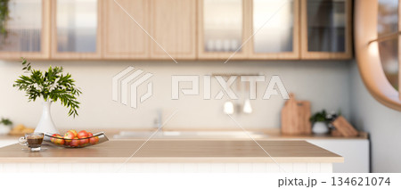 Cup of coffee and apples on plate with flower vase on wooden top counter or dining table in kitchen. 134621074
