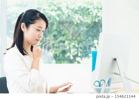 パソコンで資料作成する若い女性 パソコンで資料作成する若い女性 134621144