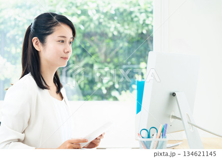 パソコンで資料作成する若い女性 パソコンで資料作成する若い女性 134621145