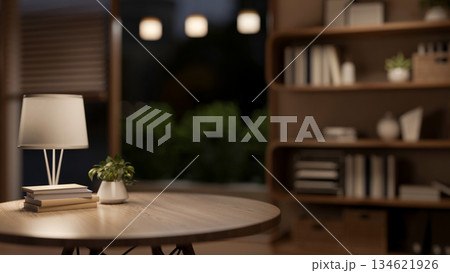 Books under lamp on round wooden table with blurred background of a living room or bedroom at night. Books under lamp on round wooden table with blurred background of a living room or bedroom at night. 134621926