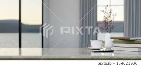Coffee cup aside books and flower vase on marble counter in living room or cafe with scenery outside Coffee cup aside books and flower vase on marble counter in living room or cafe with scenery outside 134621930