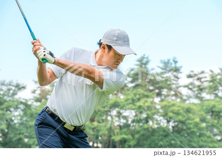 ゴルフ場でティーショットを打つゴルファーの男性(ゴルフスイング) ゴルフ場でティーショットを打つゴルファーの男性(ゴルフスイング) 134621955