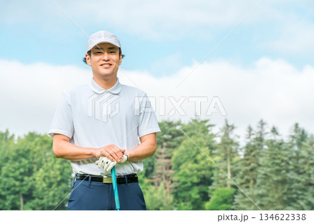 新緑の中でゴルフウェアを着た男性ゴルファー（ゴルフコース・アカデミー・会員権） 134622338