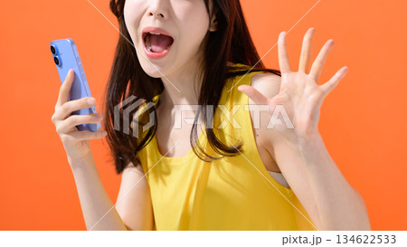 スマホを持って驚く女性 134622533