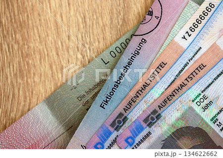 German Permanent resident card and document specimen lies on wooden table close up. Aufenthaltstitel and Fiktionsbescheinigung 134622662
