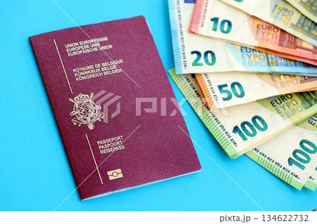 Belgium passport lies with euro money banknotes on blue background close up. Salary and pension in Europe concept Belgium passport lies with euro money banknotes on blue background close up. Salary and pension in Europe concept 134622732