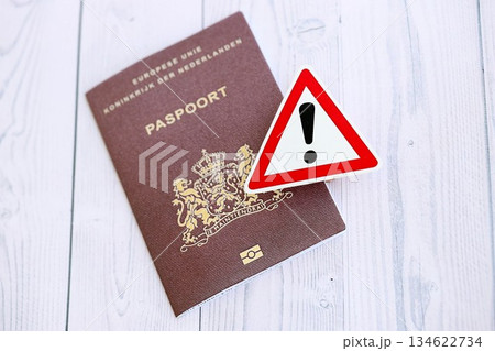 Netherlands passport with exclamation sign on white wooden background close up. Problems with citizenship in Europe concept Netherlands passport with exclamation sign on white wooden background close up. Problems with citizenship in Europe concept 134622734