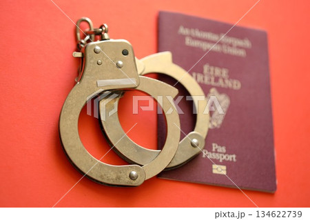 Ireland passport with police handcuffs on table close up. Criminal level and arrests in Europe concept 134622739