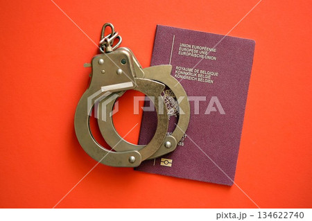 Belgium passport with police handcuffs on table close up. Criminal level and arrests in Europe concept 134622740