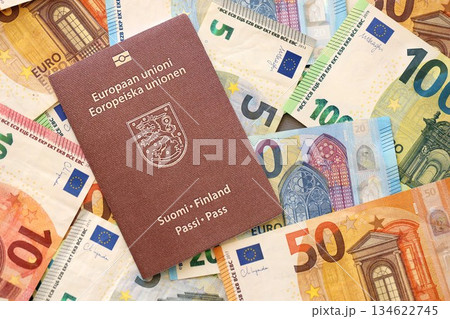 Finland passport lies on big amount of euro money banknotes close up. Rich life and travel in Europe concept Finland passport lies on big amount of euro money banknotes close up. Rich life and travel in Europe concept 134622745