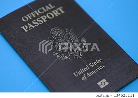 United States official passport book on light blue paper background close up. Travel document on blue surface 134623111