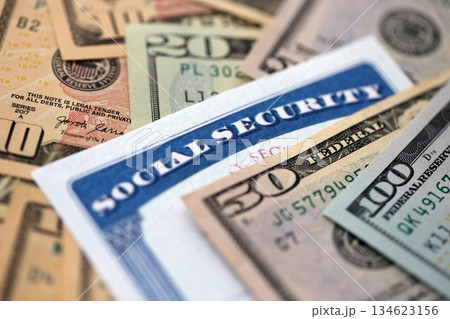 Social security number card on many US dollar money bills close up Social security number card on many US dollar money bills close up 134623156